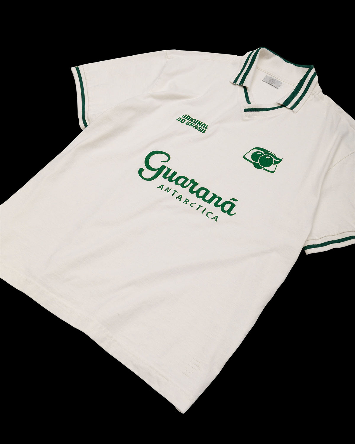 Laydown de frente da Jersey Cotton Kiji Studio para Guaraná Antarctica, na cor off white, silk verde e detalhes na gola e manga em verde.