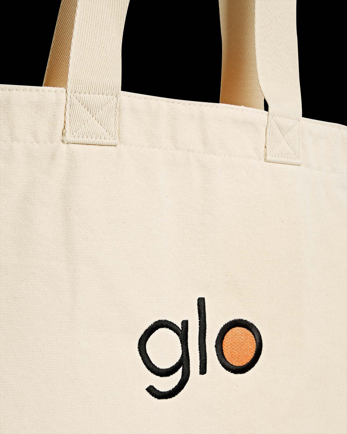 Detalhe frente Heavy Tote Bag Kiji Studio para Glo, na cor cru com bordado 'Glo'.